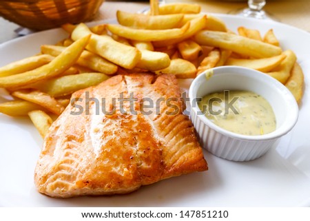 grilled salmon and fries - french cuisine dish with tomato and salmon