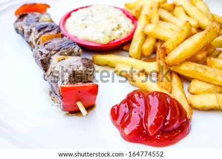 tasty grilled meat and vegetables skewers on a slate plate