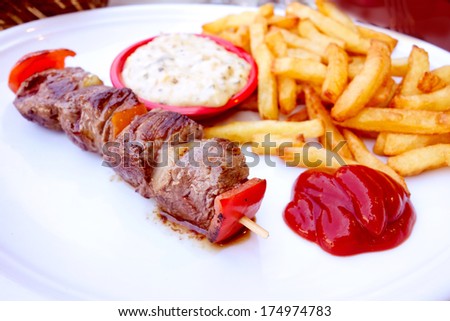 tasty beef steak kabobs with vegetables on a slate plate