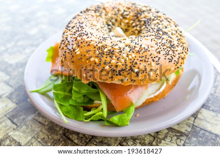 Fresh Salmon Bagel with fresh cheese and fresh lettuce on table