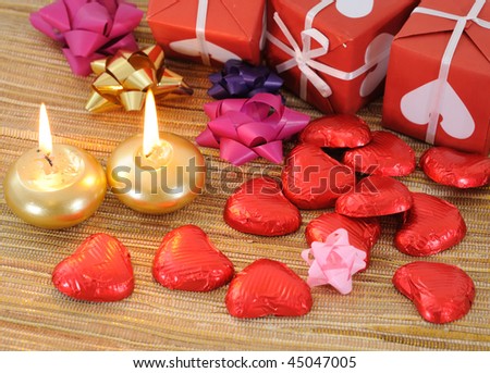 Red gift box with ribbons and candle