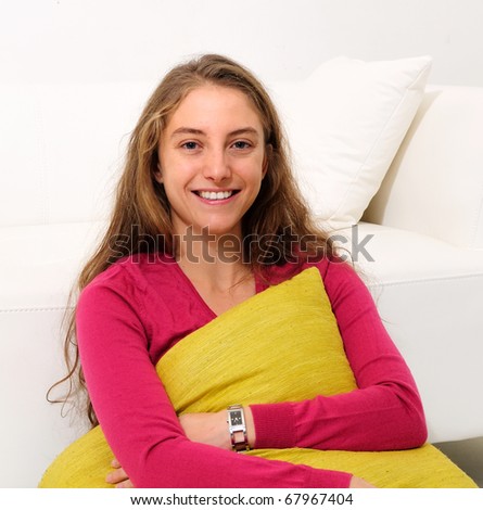 beautiful young woman with green pillow and wearing jeans
