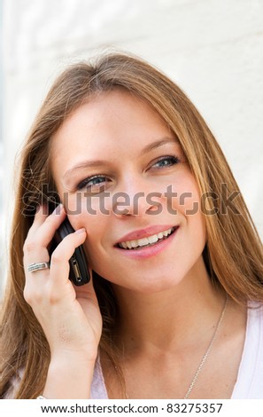 Outdoor portrait young woman talk on a cellular telephone