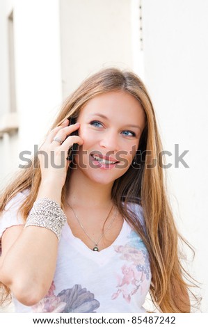 Portrait of a smiling young businessman giving call me gesture on white background
