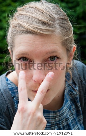 angry young woman pointing to the eyes