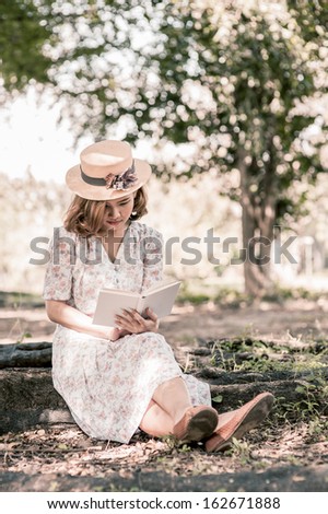 Vintage girl reading book in park