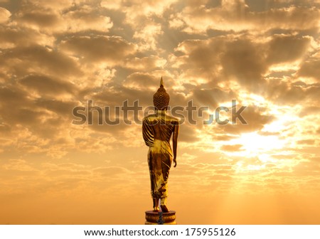 Golden Buddha statue in Wat Phra That Khao Noi, Nan Province, Thailand facing sun light