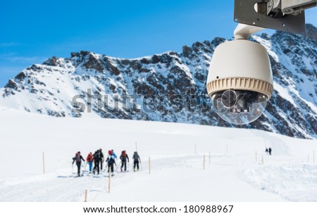 CCTV Camera Operating on snow mountain with people hiking in backgroun