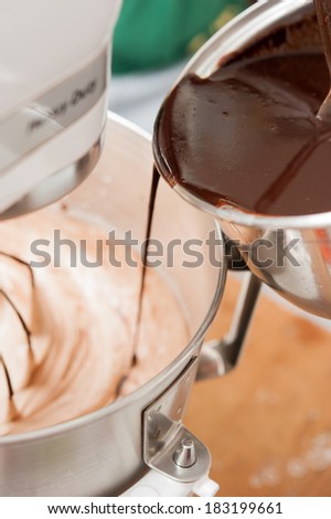 Mixing flour, eggs, sugar and hot chocolate in mixing machine