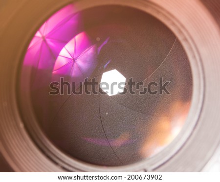 The diaphragm of a camera lens aperture. Selective focus with shallow depth of field. Color toned image