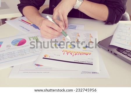 man working on paper chart, performance reporting, business concept