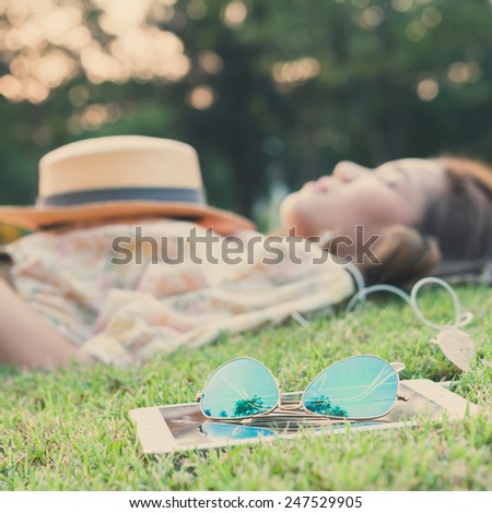 fashion sun glasses with young woman sleeping in background, vintage style