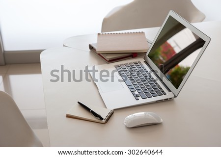 Laptop with book on work desk