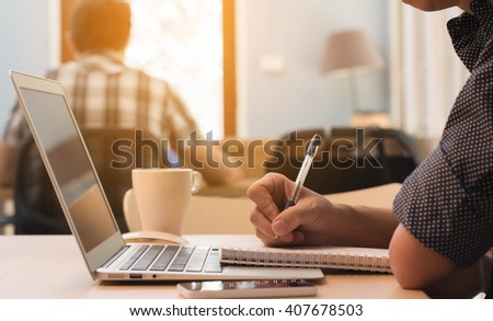 Man taking note with laptop in co-working space