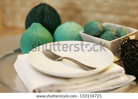 An elegant table setting with plate fork and green decorations