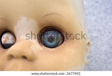 Close up of an an old worm doll with blue eyes
