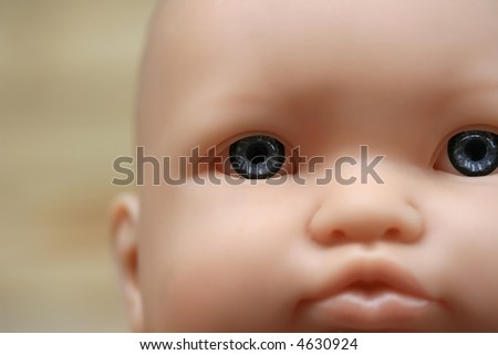 A close up a plastic doll face with blue eyes