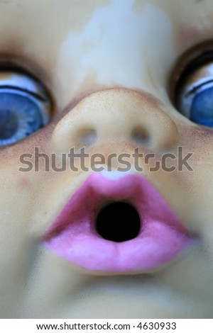 A close up of a doll face with pink lips