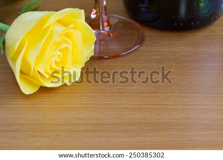 Yellow rose with a bottle of wine and a glass