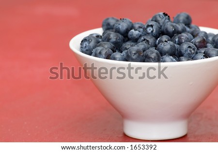 bowl of blueberries in white bowl on red table