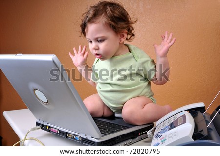 Baby sitting on top of laptop looking confused with hands in the air as if to say \
