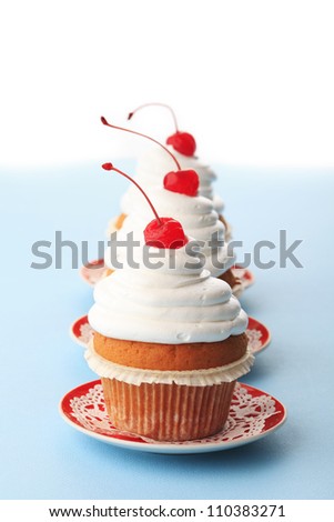 Three cupcakes with maraschino cherry