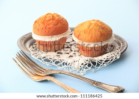 Freshly baked assorted muffin on a cake stand on blue background