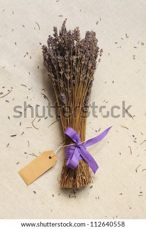 A bunch of dried lavender with blank card (tag) on linen canvas background