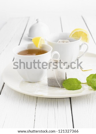 Teabag with blank label and two cups of tea lemon, mint. Shallow DOF