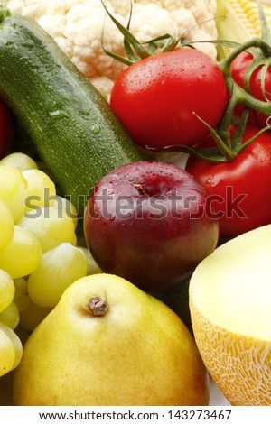 Various, assorted fruits and vegetables( cauliflower, tomato, pear, grape, plum, melon, zucchini, green apple). Vibrant color.