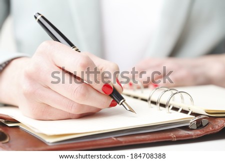 Close-up of businesswoman holding fountain pen in hand.