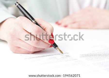 Close-up of businesswoman\'s hand, while fill the form. Small business.