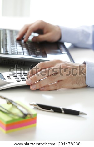Financial adviser calculating data while working at bank.