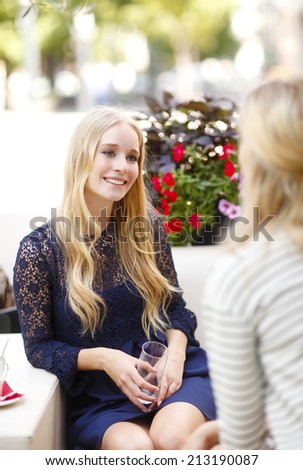 Portrait of two attractive female friends meeting at coffee shop.