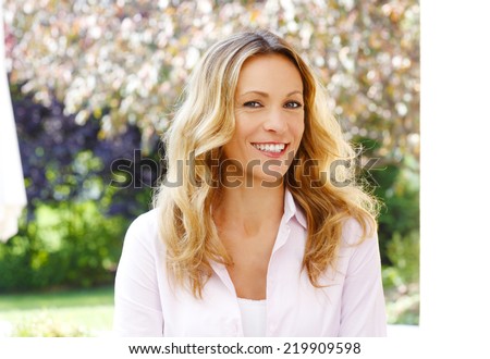 Close-up portrait of beautiful mature woman sitting at garden.