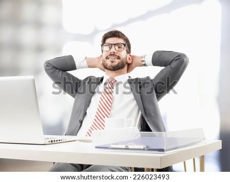 Close-up portrait of young broker relaxing and  leaning back at office. Business people.