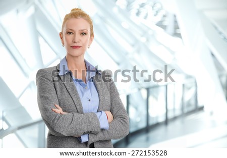 Portrait of arms crossed bank employee standing at office while looking at camera and arms crossed. Business person.