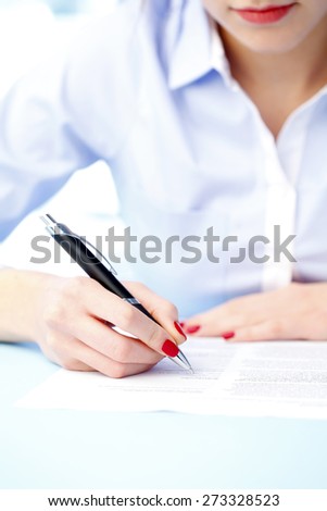 Close-up portrait of businesswoman filling the form on job interview. Business person sitting at desk while working at office.