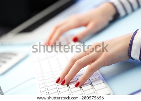 Image of female student working her presentation while sitting at desk and writing on keyboard.