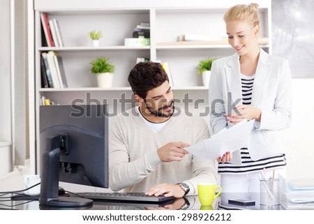 Portrait of young financial manager and his female assistant analyzing data while working online. Business people consulting at office.