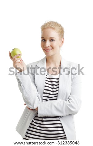 Portrait of young woman holding hand green apple while looking at camera and smiling. Isolated on white background.