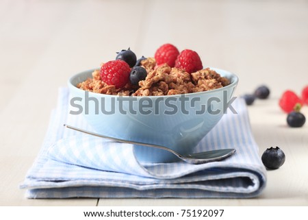 Bowl of breakfast healthy muesli with raspberry and blueberries