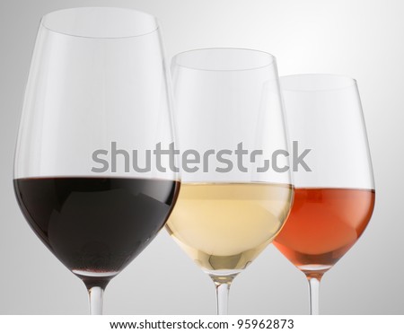 Glasses of red, white and rose wine (Shallow focus. Focus on white wine)