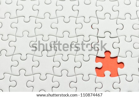 Plain white jigsaw puzzle, on orange background.