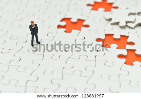 Plain white jigsaw puzzle and Businessman, on Orange background.