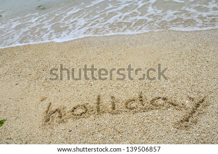 inscription Holiday on the sand at the beach in summer.