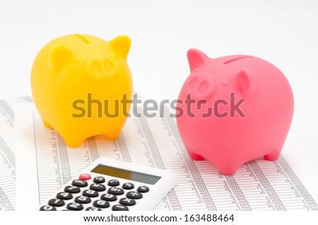 Piggy bank (Pink and Yellow) and calculator isolated on white background.