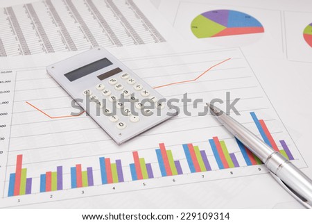 Business performance analysis. Business Graphs with calculator, pen.