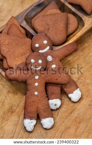 two gingerbread man and christmas gingerbread on wooden background