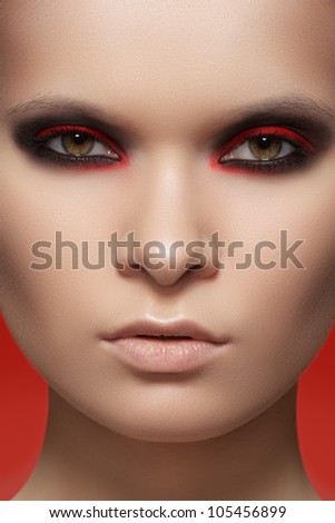 Close-up beauty portrait of attractive model face with bright fashion make-up. Devil style visage for Halloween